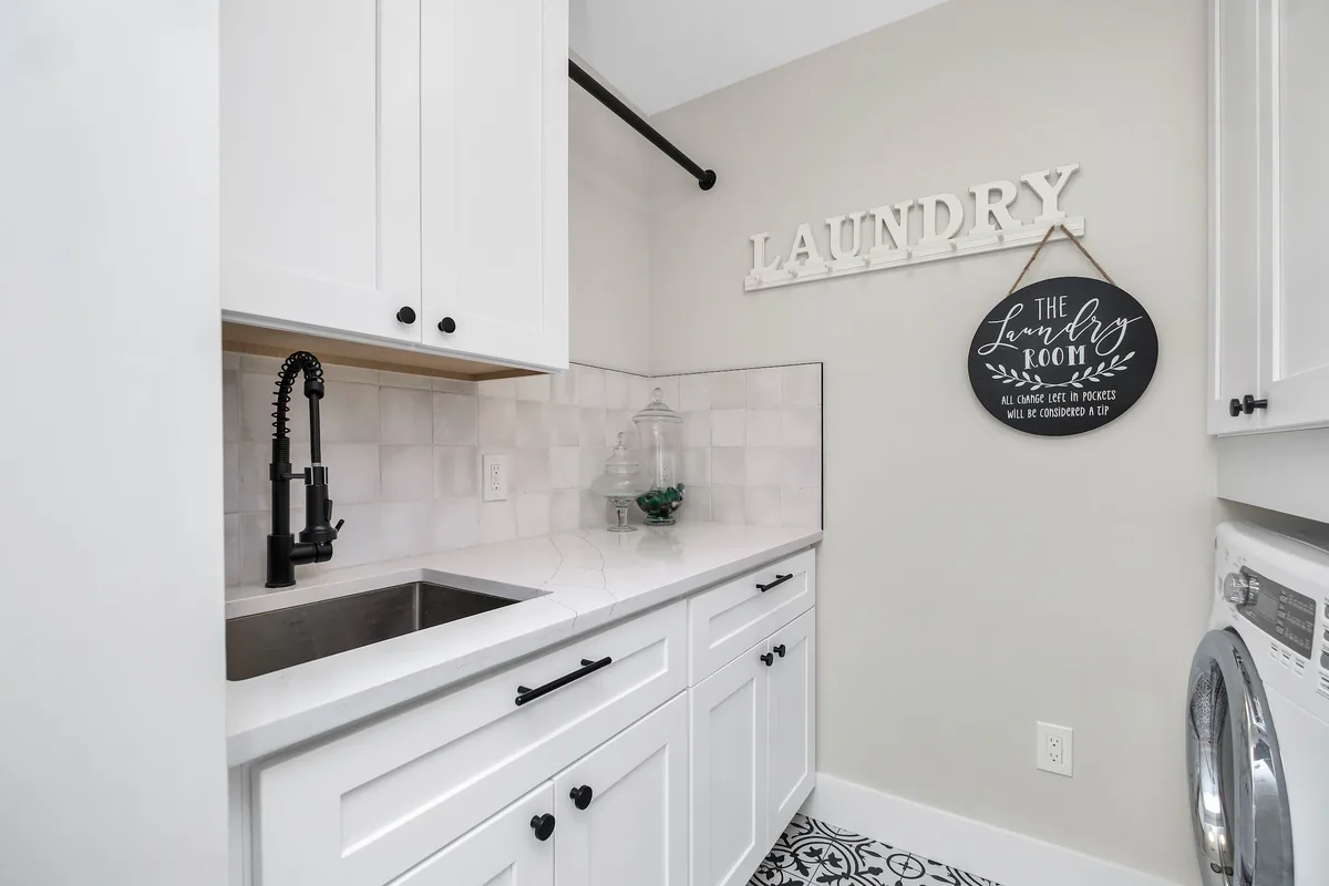 A finished Florida laundry room with waterproof tile flooring, moisture-tolerant cabinetry, and a folding counter
