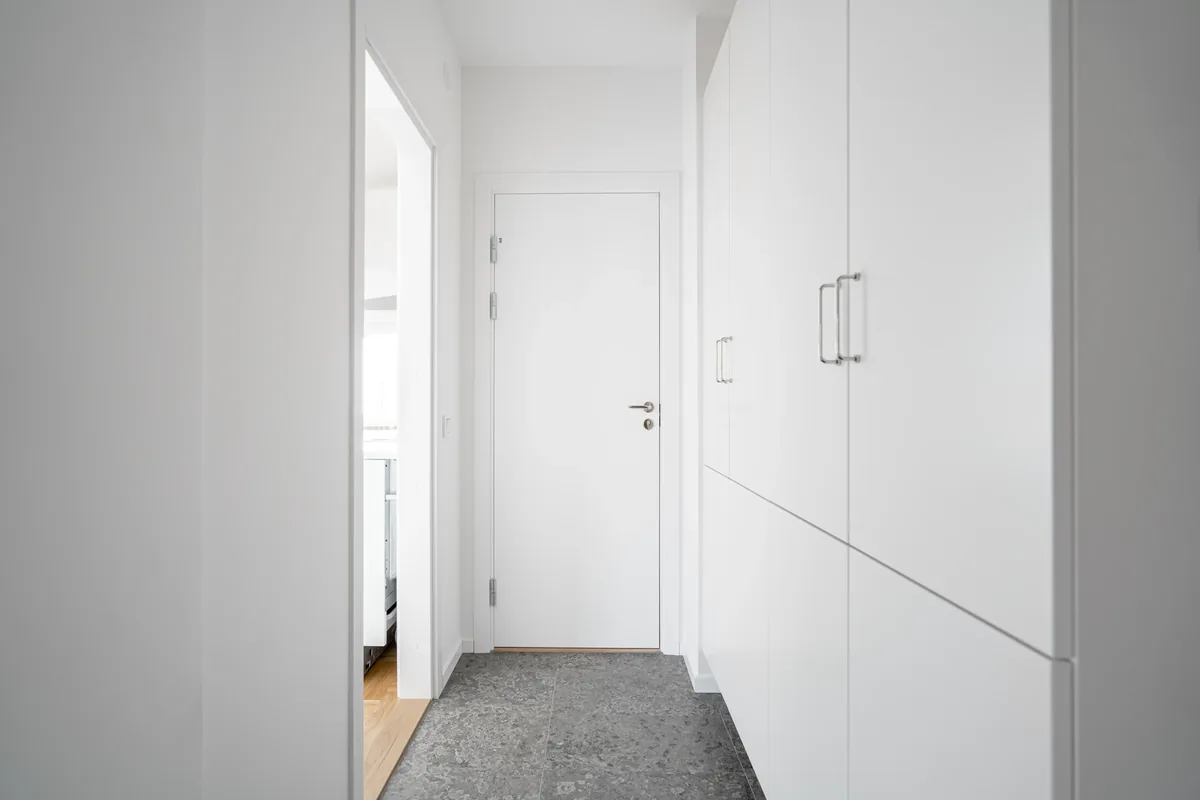 A Florida mudroom drop zone with sealed porcelain tile, a wipe-clean bench, and open lockers for wet beach gear