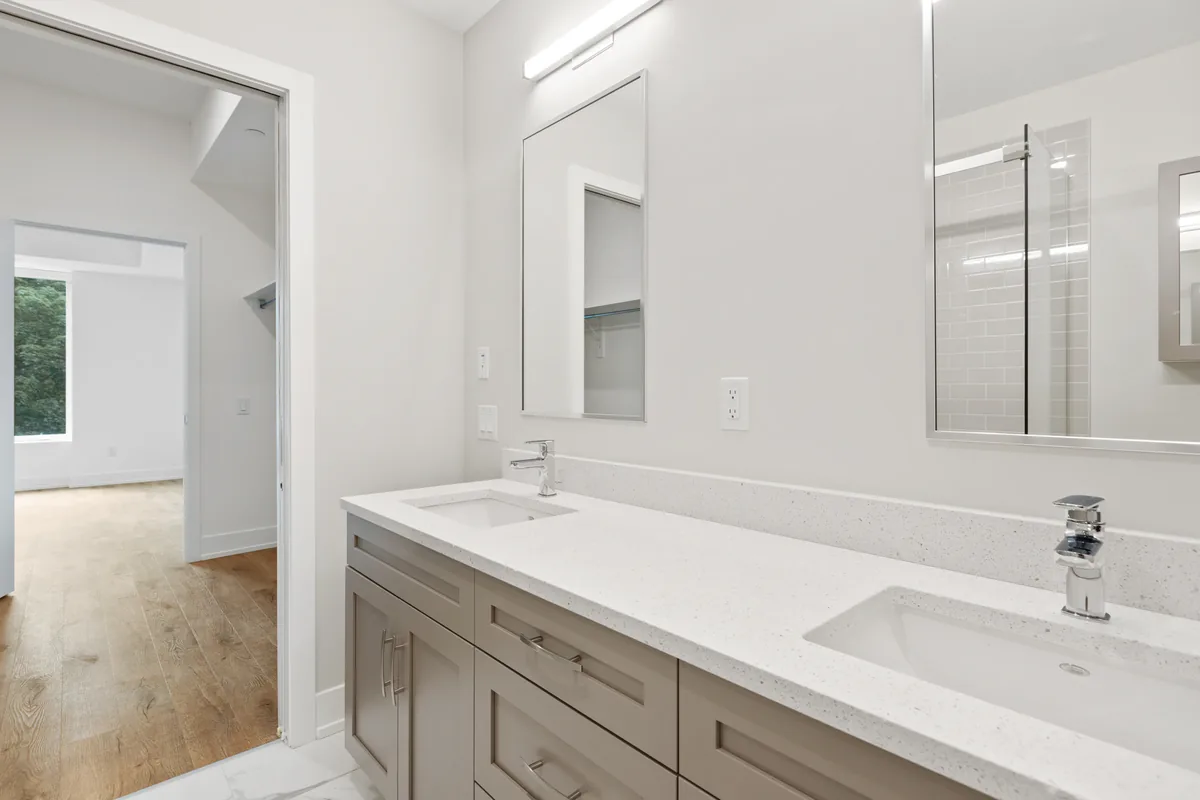 A Florida master bathroom under construction showing the spa shower wet area being waterproofed before the dual vanity goes in