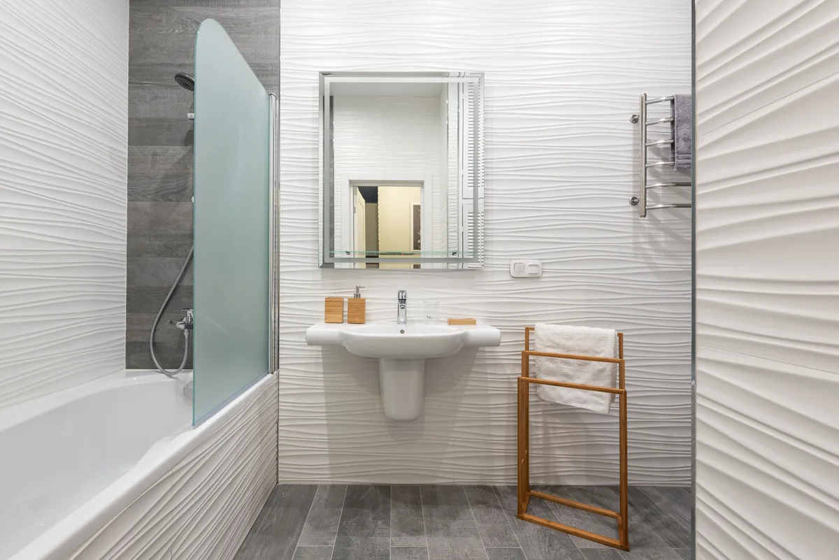 A finished Florida tub-to-shower conversion with an easy-entry walk-in shower, bench, grab bar, and slip-rated tile
