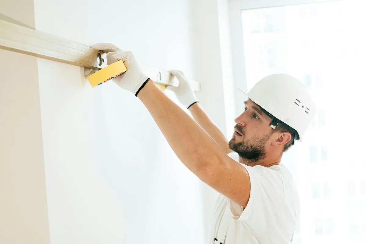 Installer shimming and scribing a bathroom vanity level against an uneven Florida wall