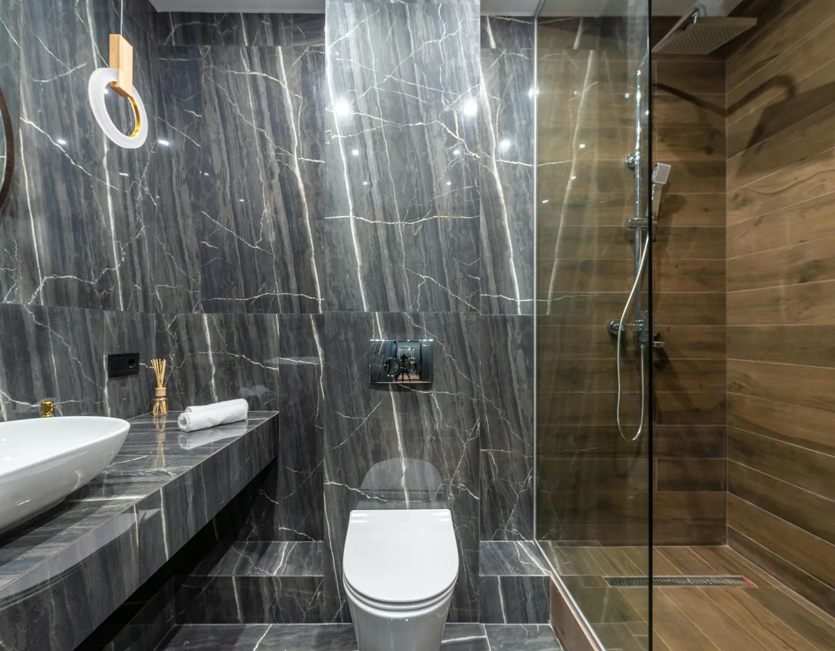 A finished Florida walk-in shower with slip-rated tile, a built-in bench, a grab bar, and frameless glass