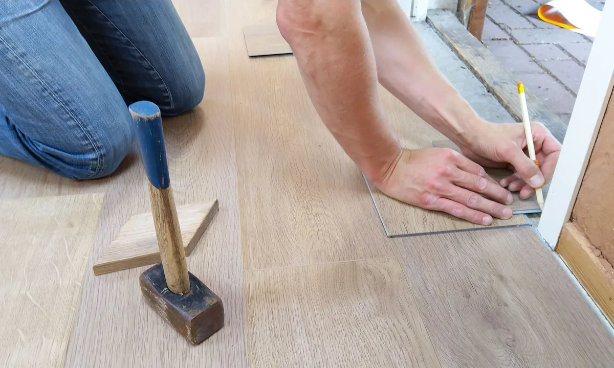 Installer applying a moisture-resistant sealing finish to all faces of a butcher block countertop in a Florida kitchen