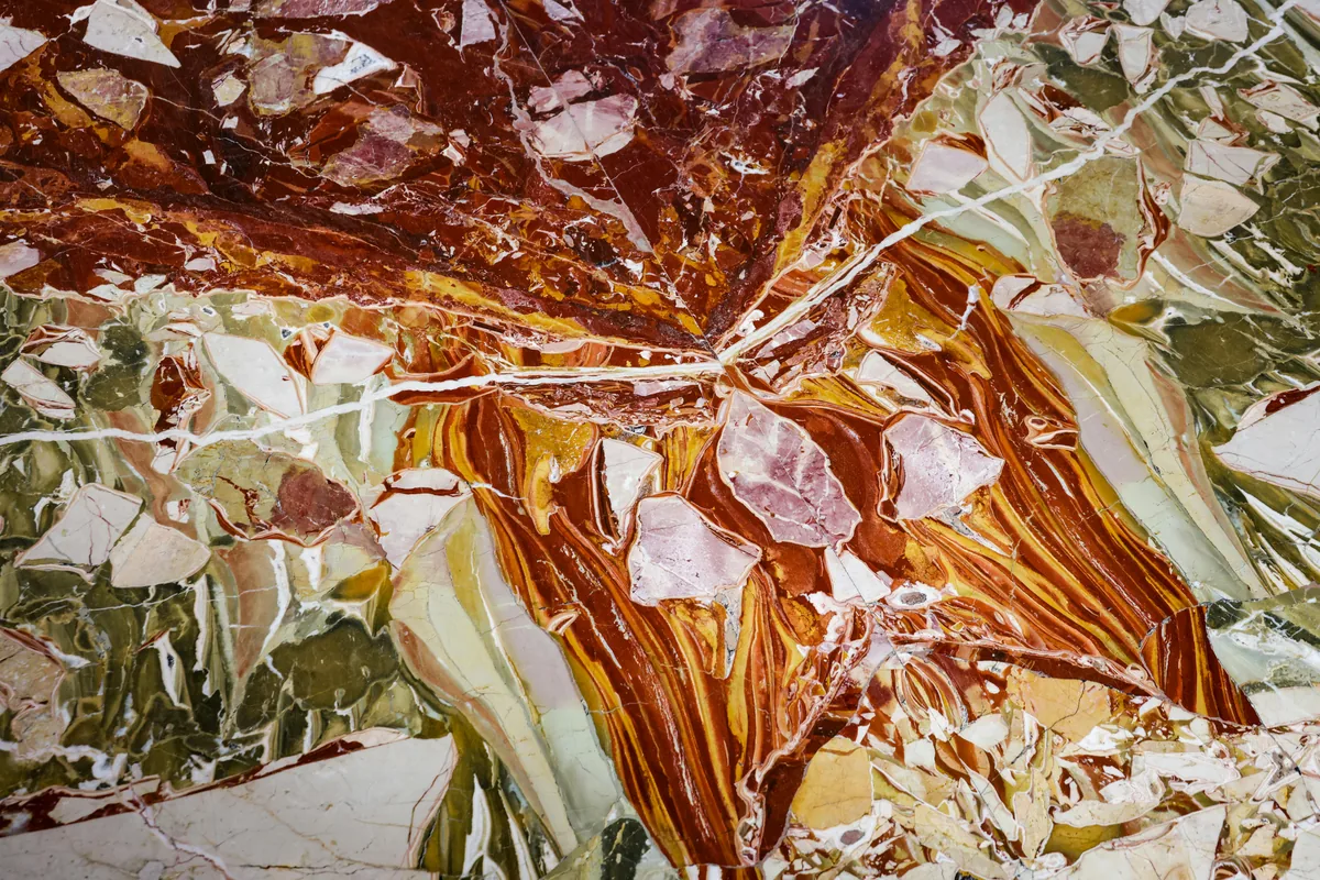Close-up of a natural quartzite slab showing marble-like veining and a polished edge