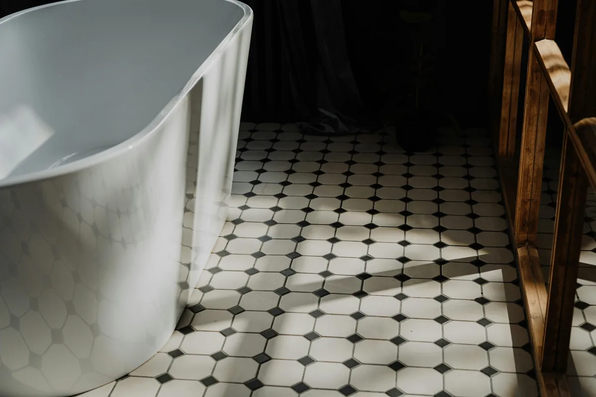Cross-section of a Florida bathroom floor assembly showing slab, bonded waterproofing membrane, thinset, and porcelain tile