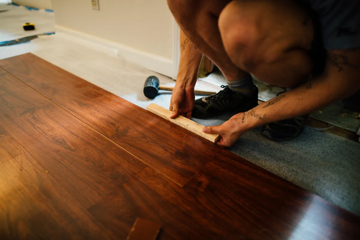 Wood-moisture meter reading planks acclimating inside a Florida home before hardwood installation