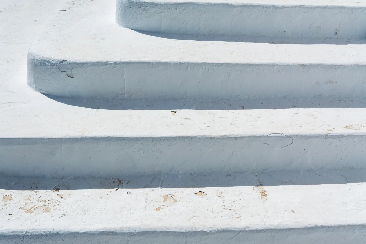 Worn stair treads being sanded back to bare wood before re-staining in a Florida home