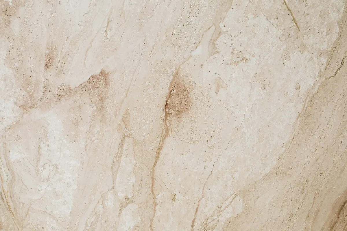 Installer back-buttering a large-format porcelain tile for full mortar coverage on a Florida floor