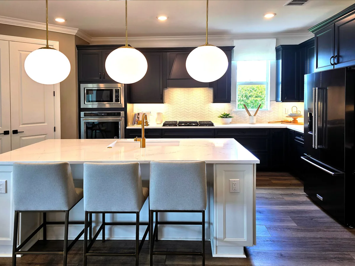 Florida kitchen island with quartz top, seating overhang, GFCI outlets, and storage cabinetry anchored to the slab