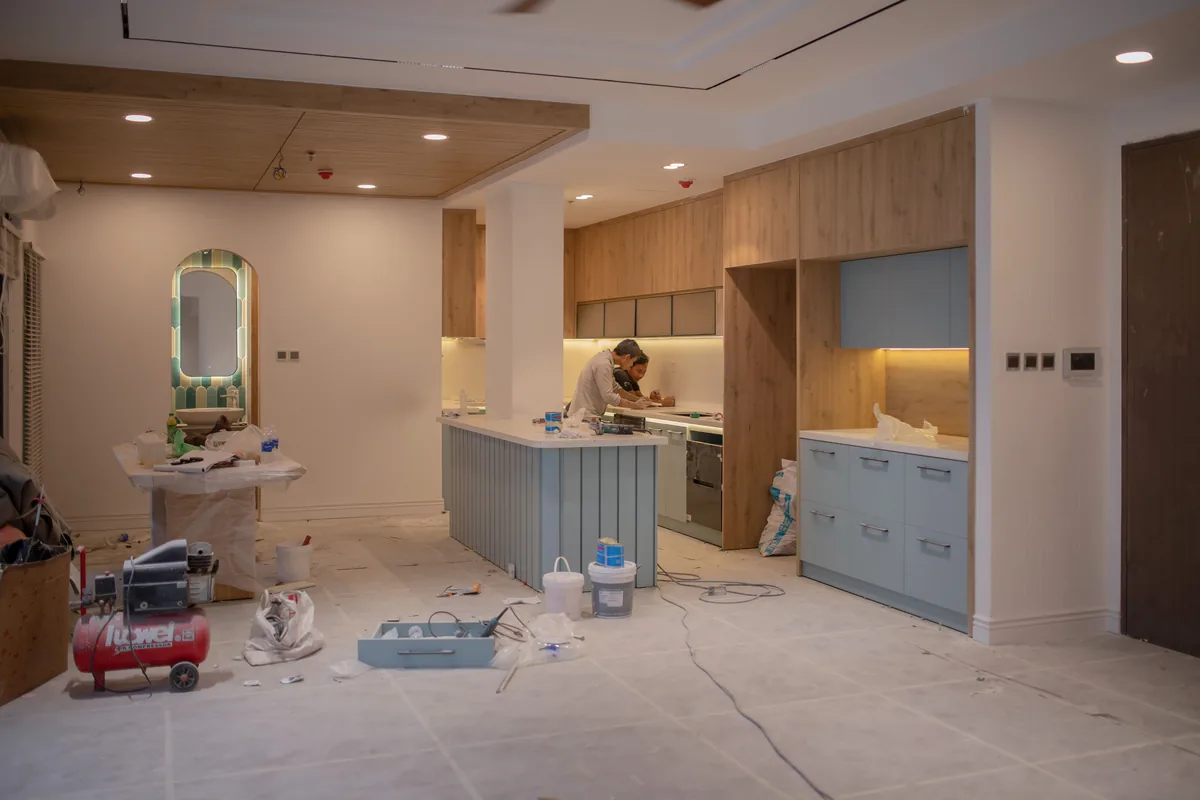 Compact Florida bungalow kitchen with moisture-tolerant cabinets, vented range hood, and waterproof flooring