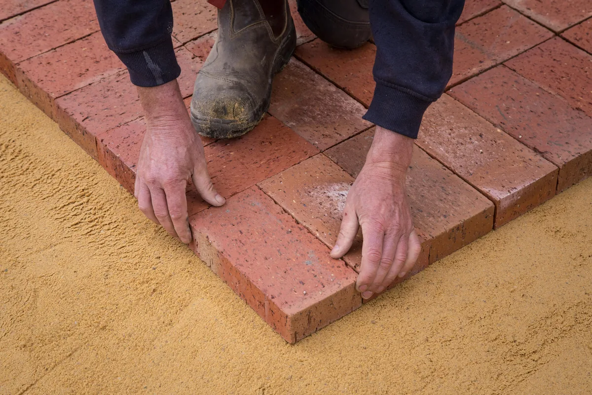 Installer sealing cement grout joints on a ceramic floor in a Florida home