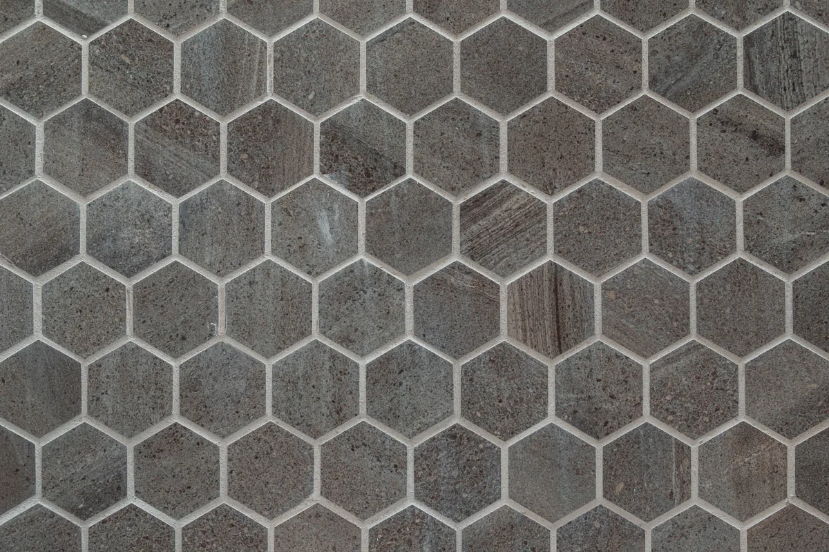 A custom herringbone shower wall with a framed mosaic niche in a Florida bathroom