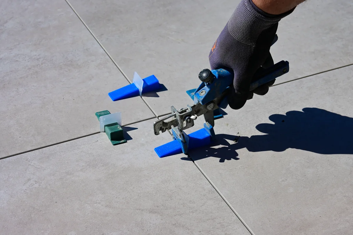 Technician applying penetrating sealer to natural stone tile in a coastal Florida home