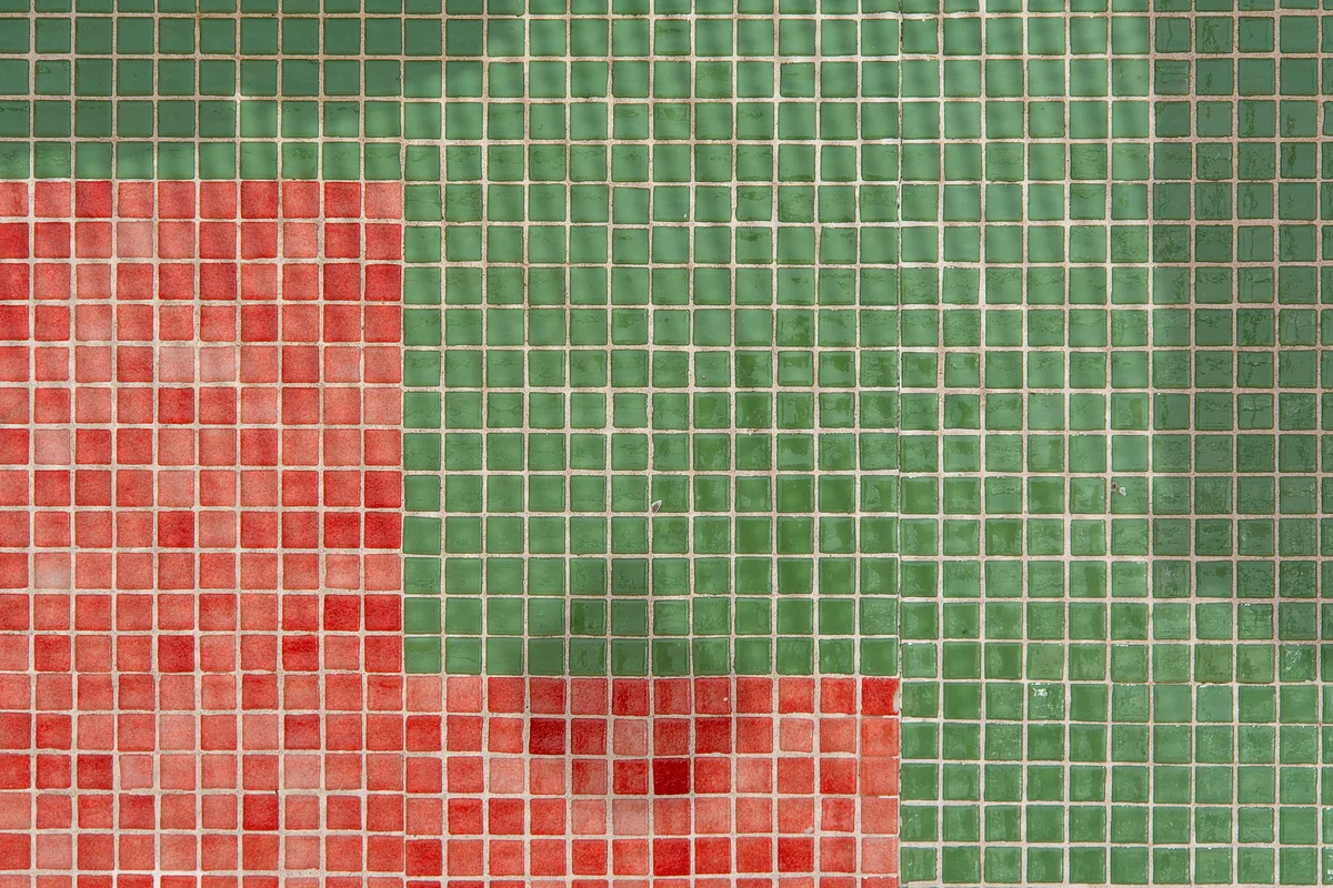 Old cracked grout being cut out of tile joints with an oscillating tool before regrouting